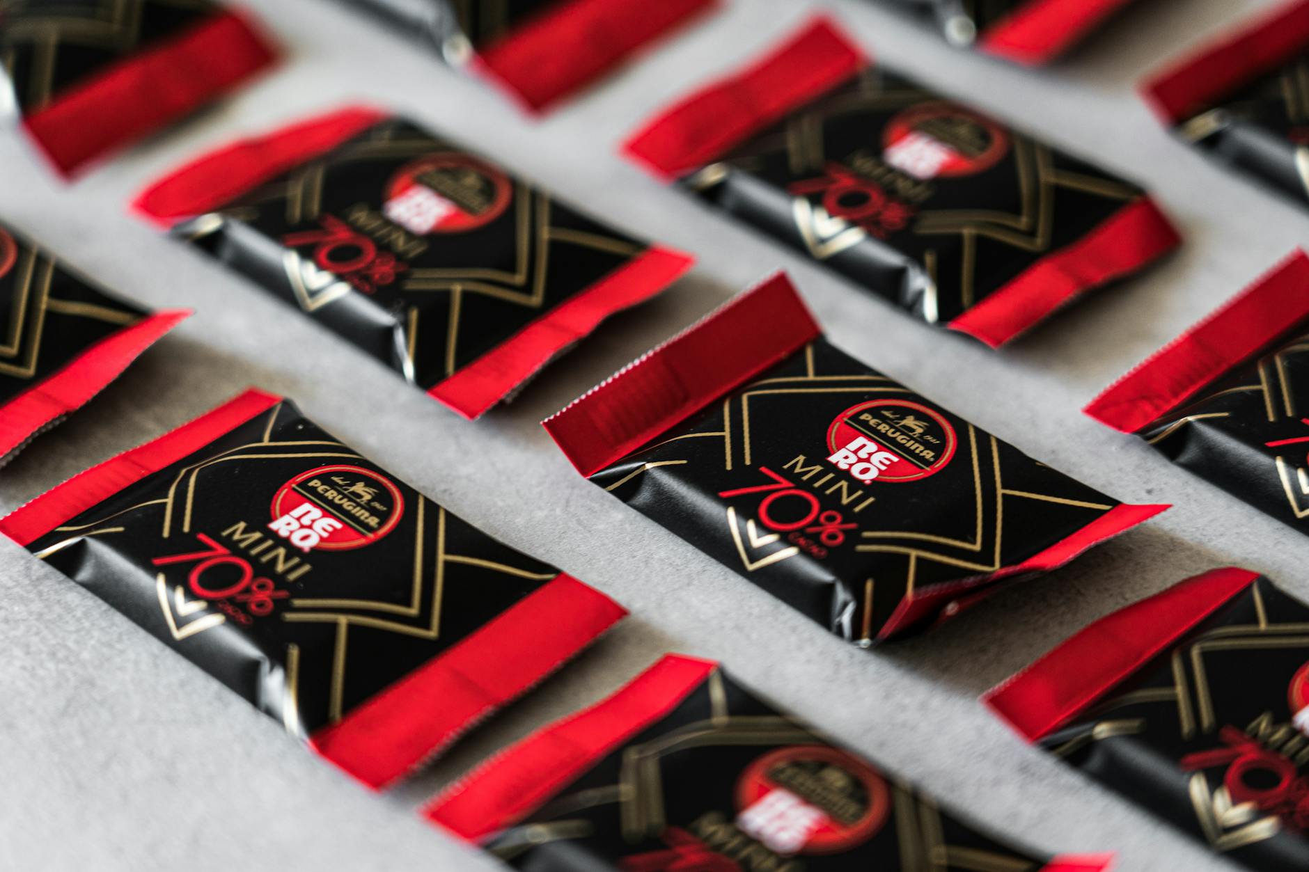 Close-up of arranged mini chocolate bars in vibrant red and black packaging, highlighting 70% cocoa content.
