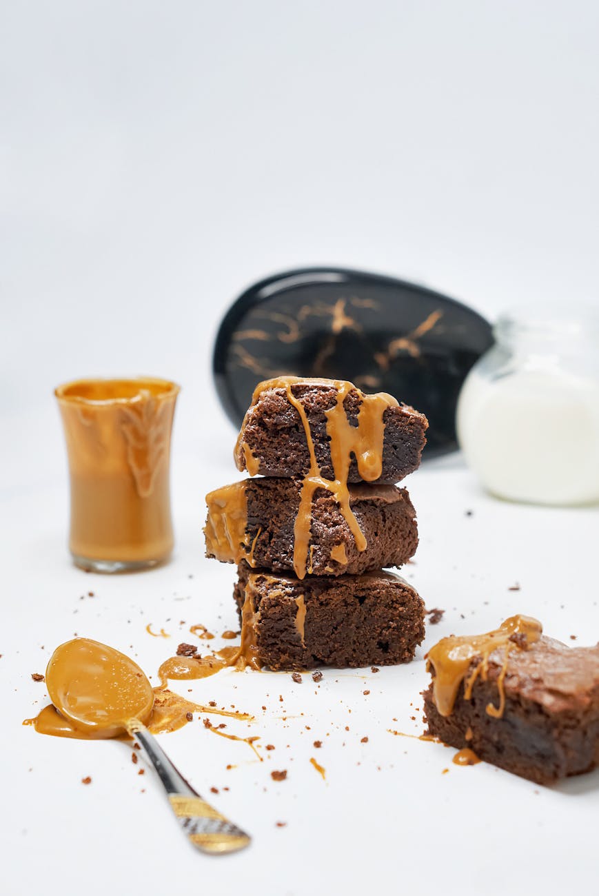 Tempting chocolate brownies with caramel on white background.